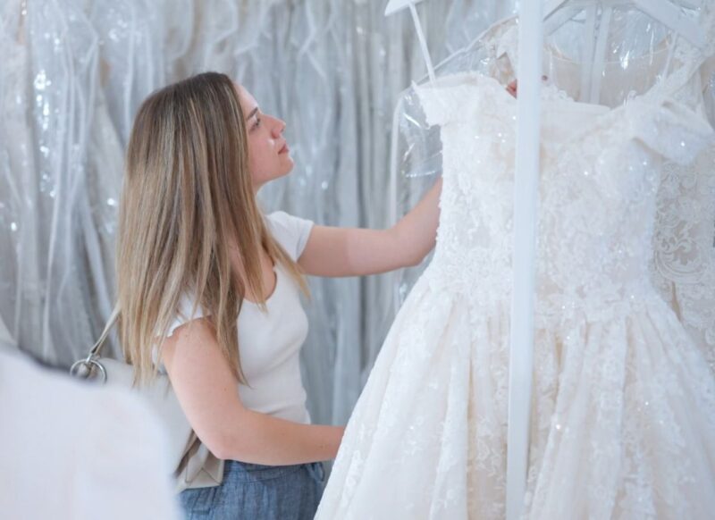 devojka bira venčanicu u salonu