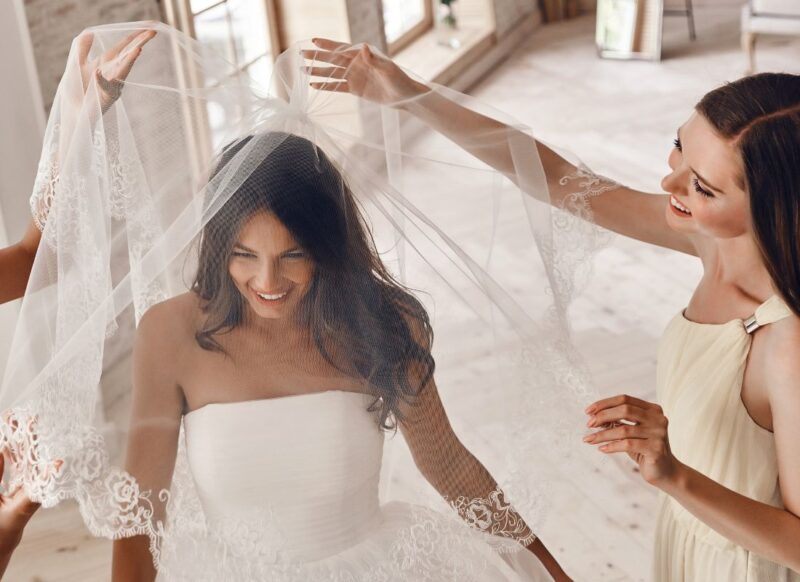 devojka stavlja veo drugarici na glavu i veselo se smeju