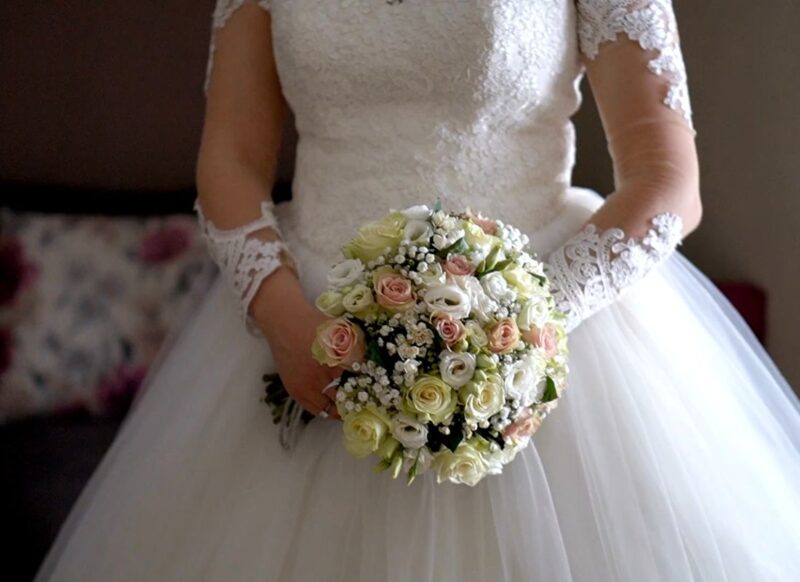 prikaz devojke koja drži bidermajer u ruci obučena u venčanicu